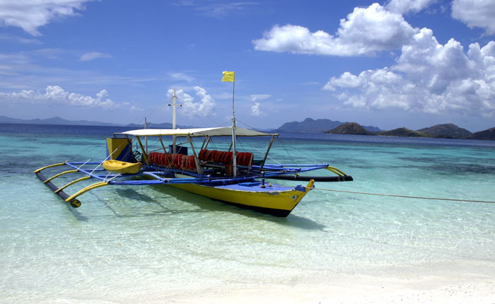 Image - a brightly painted outrigger boat, Palawan island, the Philippines.